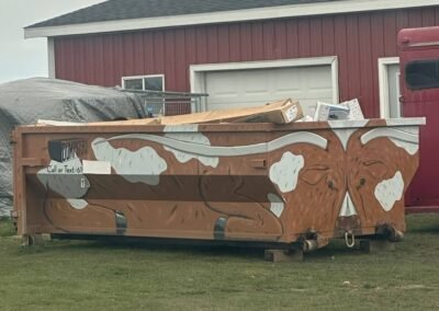 ten cubic yard roll off dumpster with bull motif sitting in front of building